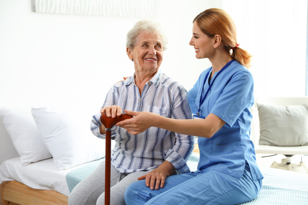 enfermera descansa sentada junto a mujer sonriente